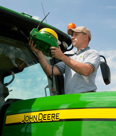 Man looking at StarFire 3000 on John Deere tractor